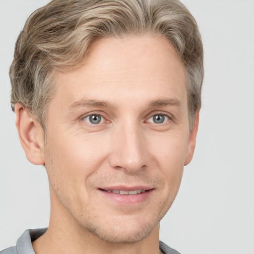 Joyful white adult male with short  brown hair and grey eyes