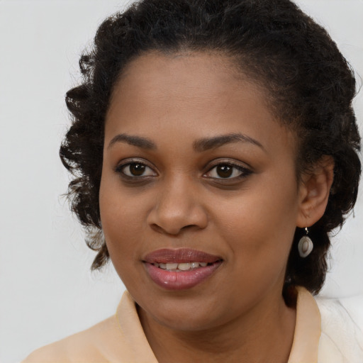 Joyful black young-adult female with medium  brown hair and brown eyes