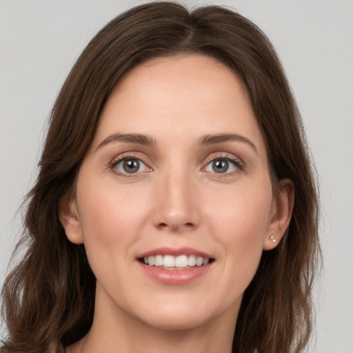 Joyful white young-adult female with long  brown hair and grey eyes