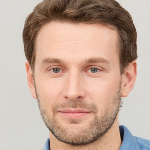 Joyful white young-adult male with short  brown hair and grey eyes