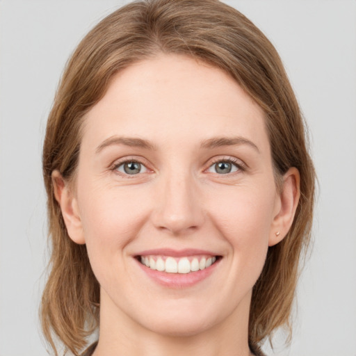 Joyful white young-adult female with medium  brown hair and green eyes