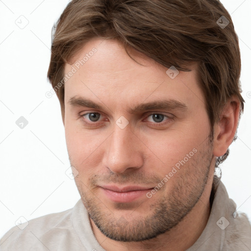 Joyful white young-adult male with short  brown hair and grey eyes