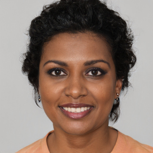 Joyful black young-adult female with short  brown hair and brown eyes