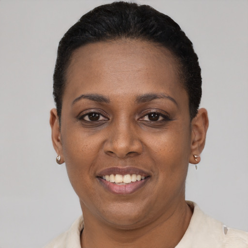 Joyful black young-adult female with short  black hair and brown eyes