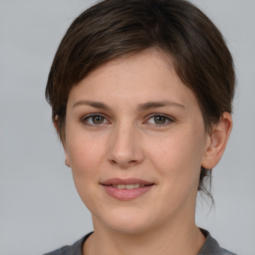 Joyful white young-adult female with medium  brown hair and grey eyes