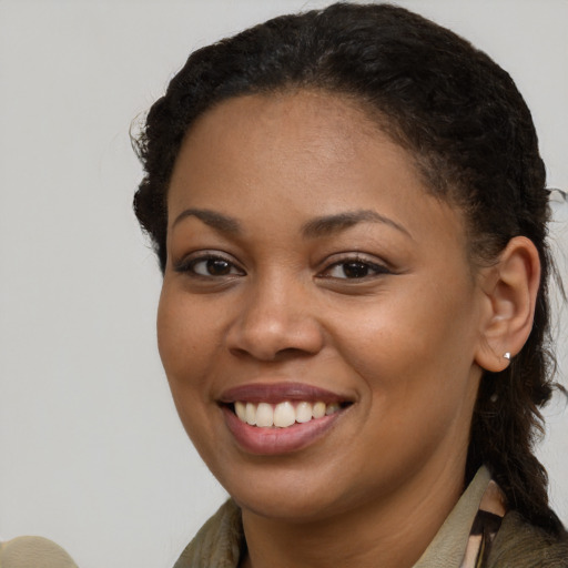 Joyful black young-adult female with long  brown hair and brown eyes