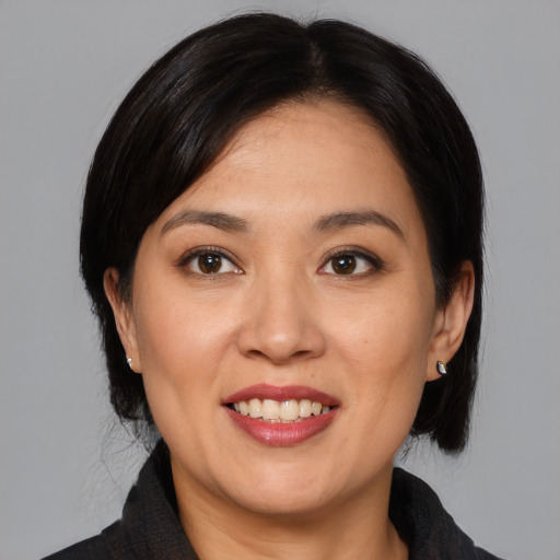 Joyful asian adult female with medium  black hair and brown eyes