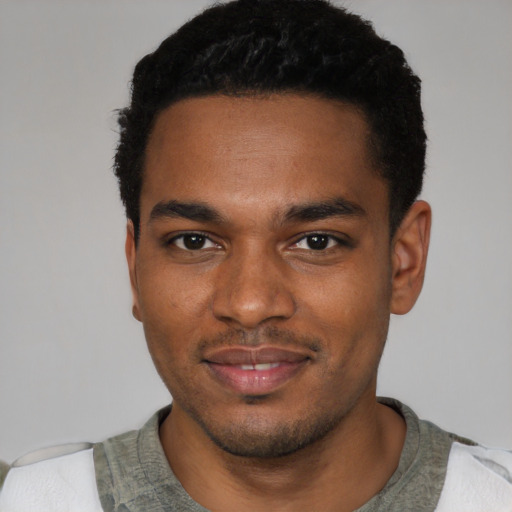 Joyful black young-adult male with short  black hair and brown eyes