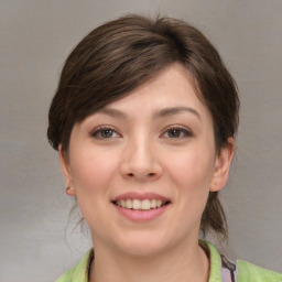 Joyful white young-adult female with medium  brown hair and grey eyes