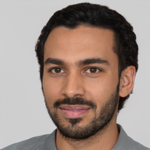 Joyful latino young-adult male with short  black hair and brown eyes