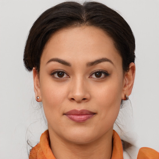 Joyful latino young-adult female with medium  brown hair and brown eyes