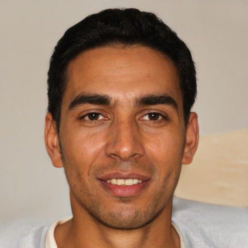 Joyful white young-adult male with short  black hair and brown eyes