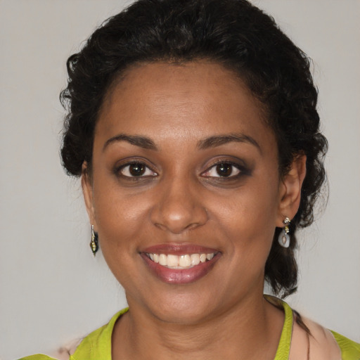 Joyful black young-adult female with short  brown hair and brown eyes