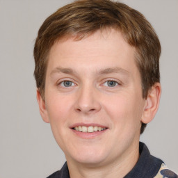 Joyful white young-adult male with short  brown hair and grey eyes