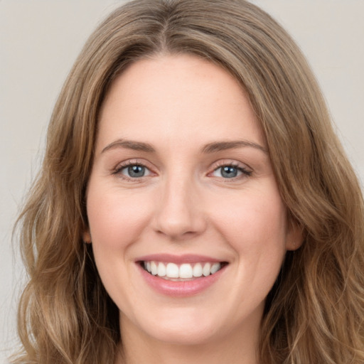 Joyful white young-adult female with long  brown hair and green eyes