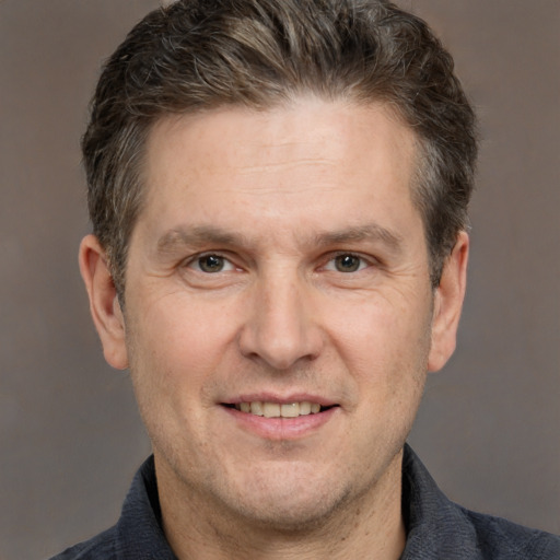 Joyful white adult male with short  brown hair and grey eyes