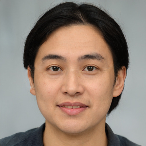 Joyful white adult male with medium  black hair and brown eyes