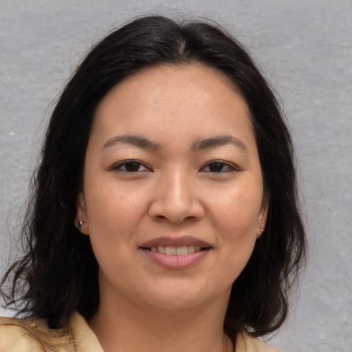 Joyful asian young-adult female with medium  brown hair and brown eyes