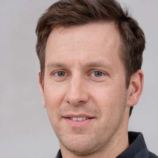 Joyful white adult male with short  brown hair and grey eyes