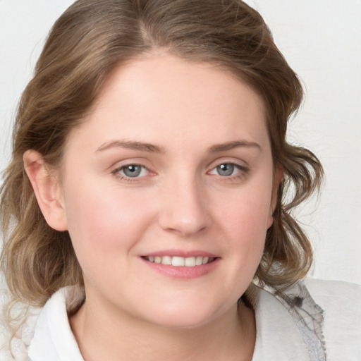 Joyful white young-adult female with medium  brown hair and blue eyes