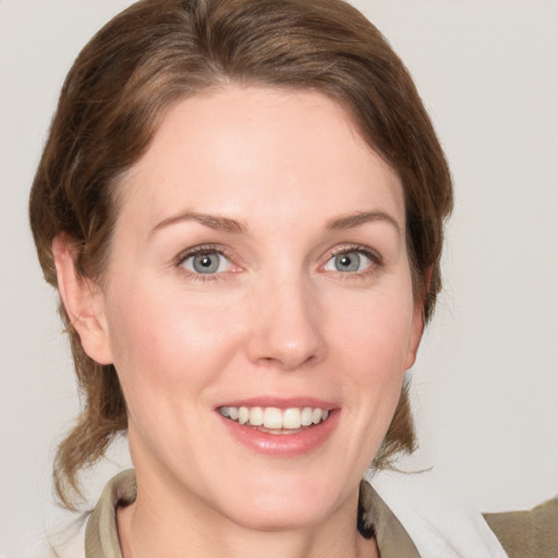 Joyful white young-adult female with medium  brown hair and grey eyes