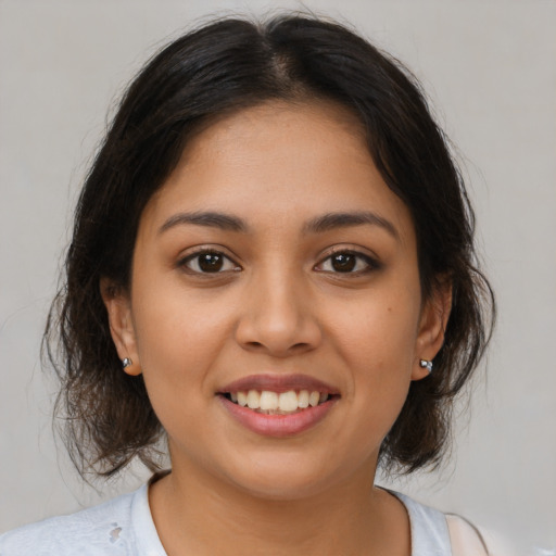 Joyful latino young-adult female with medium  brown hair and brown eyes