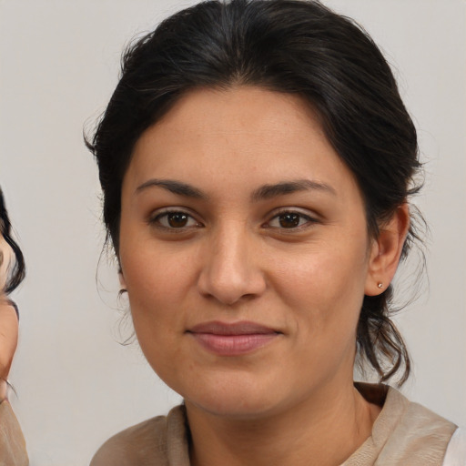 Joyful latino young-adult female with medium  brown hair and brown eyes