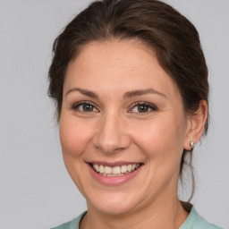 Joyful white young-adult female with medium  brown hair and grey eyes