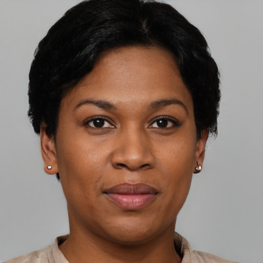 Joyful black young-adult female with short  black hair and brown eyes