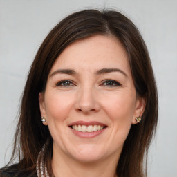 Joyful white adult female with long  brown hair and brown eyes