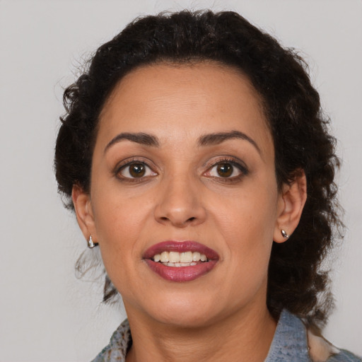 Joyful latino adult female with medium  brown hair and brown eyes