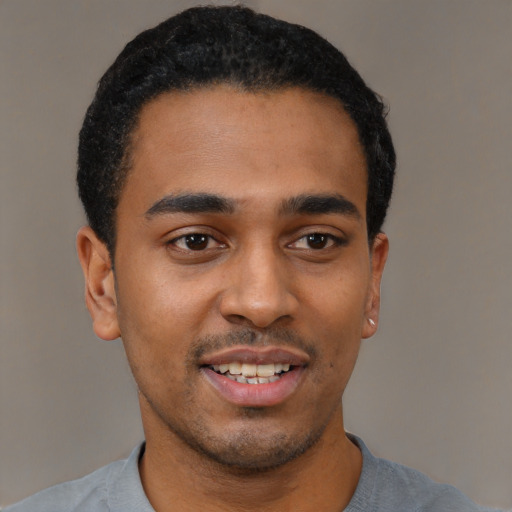 Joyful black young-adult male with short  black hair and brown eyes