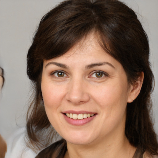 Joyful white adult female with medium  brown hair and brown eyes