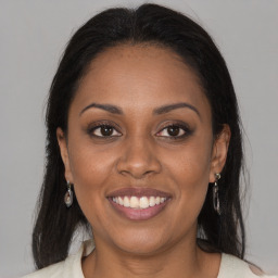 Joyful black young-adult female with long  brown hair and brown eyes