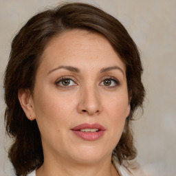 Joyful white young-adult female with medium  brown hair and green eyes