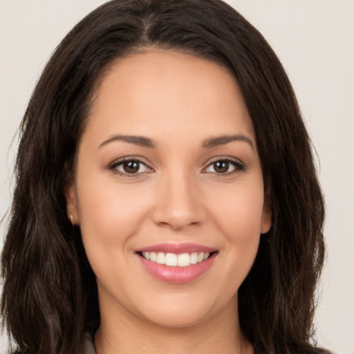 Joyful white young-adult female with long  brown hair and brown eyes