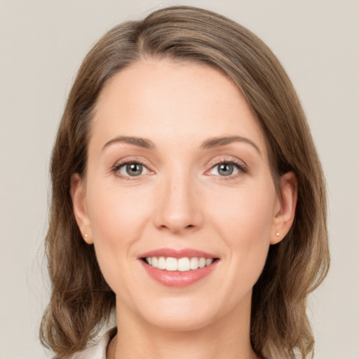 Joyful white young-adult female with medium  brown hair and green eyes