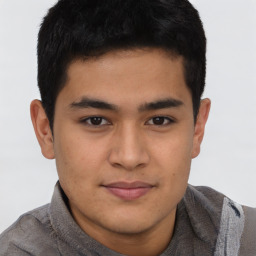 Joyful latino young-adult male with short  brown hair and brown eyes