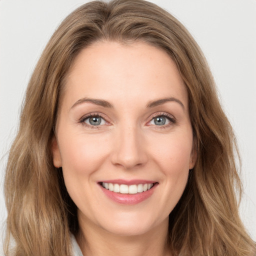 Joyful white young-adult female with long  brown hair and green eyes