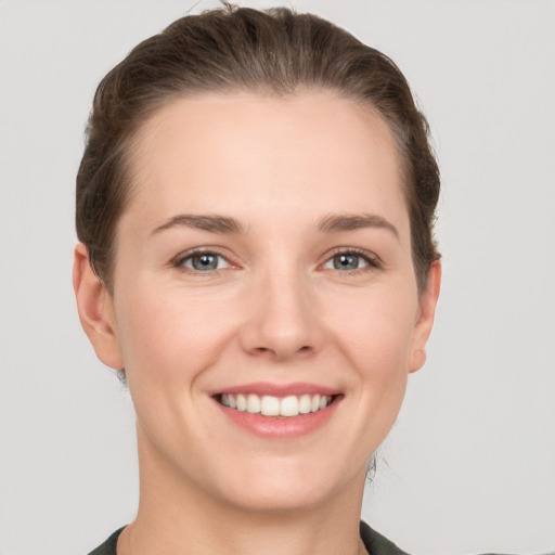 Joyful white young-adult female with short  brown hair and grey eyes