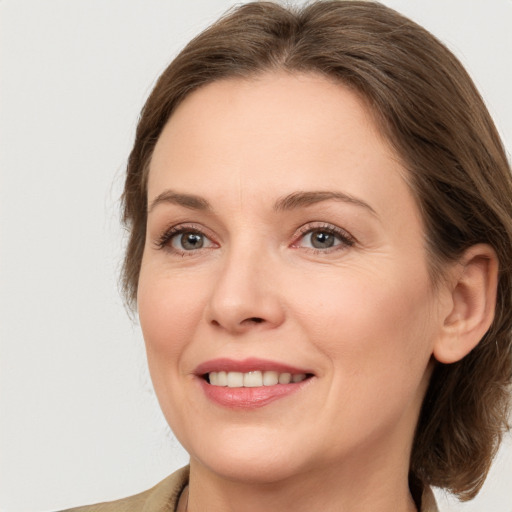 Joyful white adult female with medium  brown hair and grey eyes