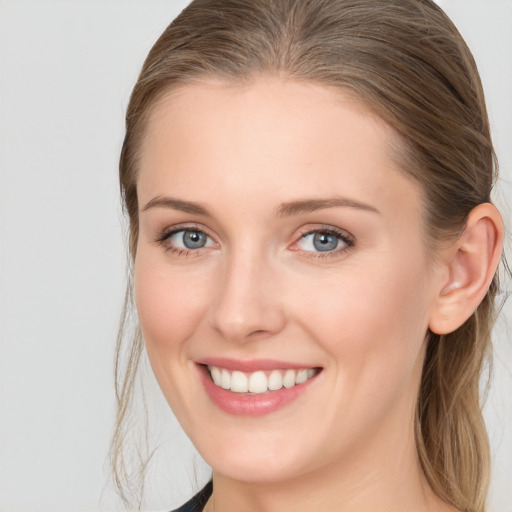 Joyful white young-adult female with long  brown hair and blue eyes