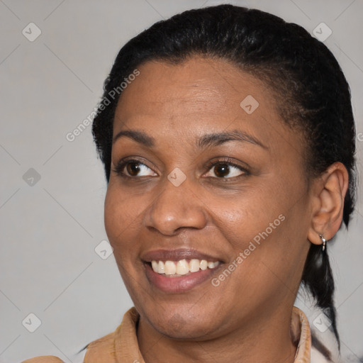 Joyful black adult female with medium  brown hair and brown eyes