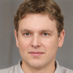 Joyful white young-adult male with short  brown hair and grey eyes