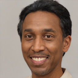 Joyful black adult male with short  black hair and brown eyes