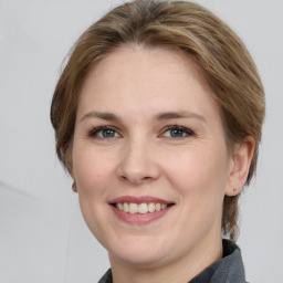 Joyful white young-adult female with medium  brown hair and grey eyes