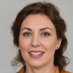 Joyful white adult female with medium  brown hair and grey eyes