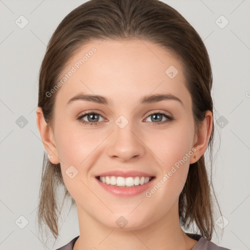 Joyful white young-adult female with medium  brown hair and grey eyes