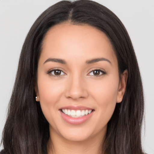 Joyful latino young-adult female with long  brown hair and brown eyes