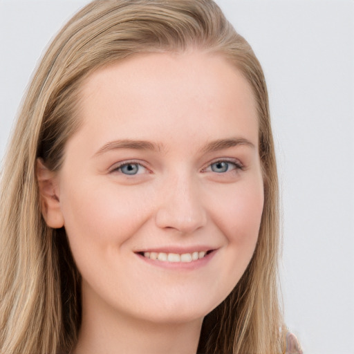 Joyful white young-adult female with long  brown hair and blue eyes